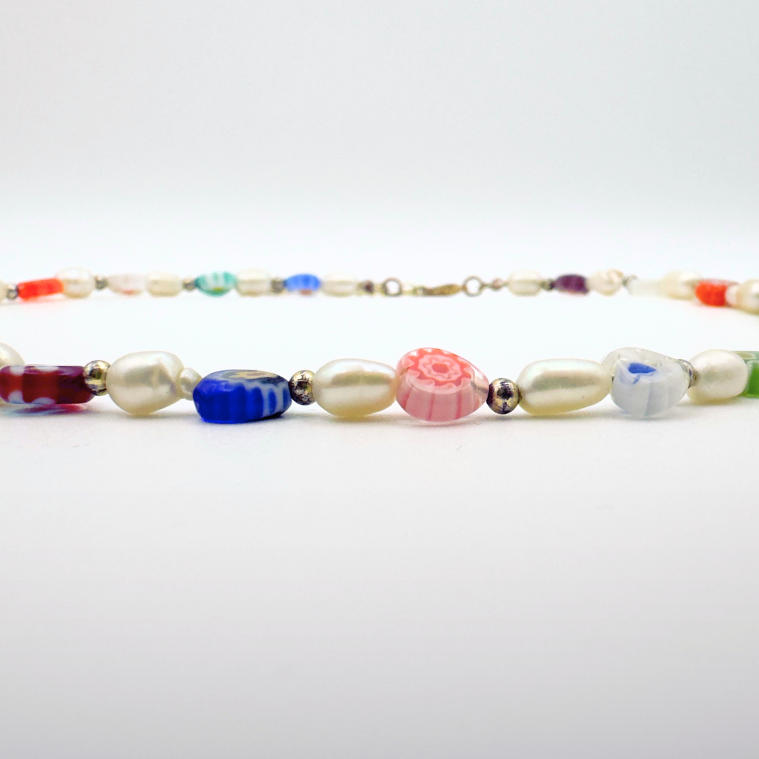 Detailaufnahme eines bunten Perlen-Chokers und goldenen Zwischenelementen