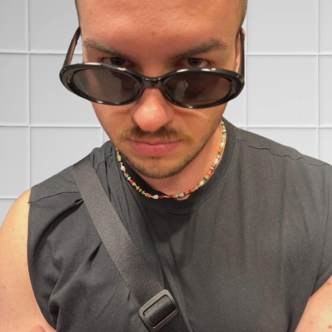 Junger Mann mit Sonnenbrille trägt bunten Perlen-Choker, Nahaufnahme des Halsbereichs