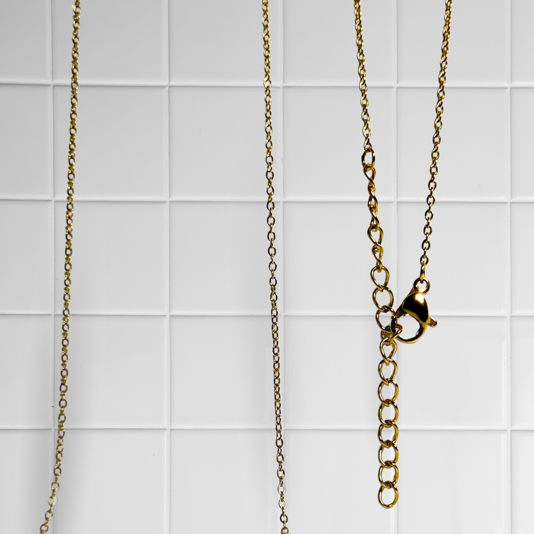 Goldene Link Chain Kette vor weißem Kachel-Hintergrund