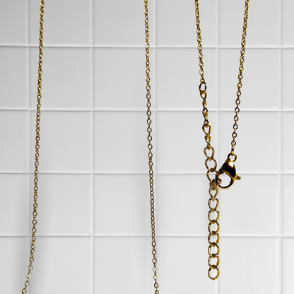 Goldene Link Chain Kette vor weißem Kachel-Hintergrund