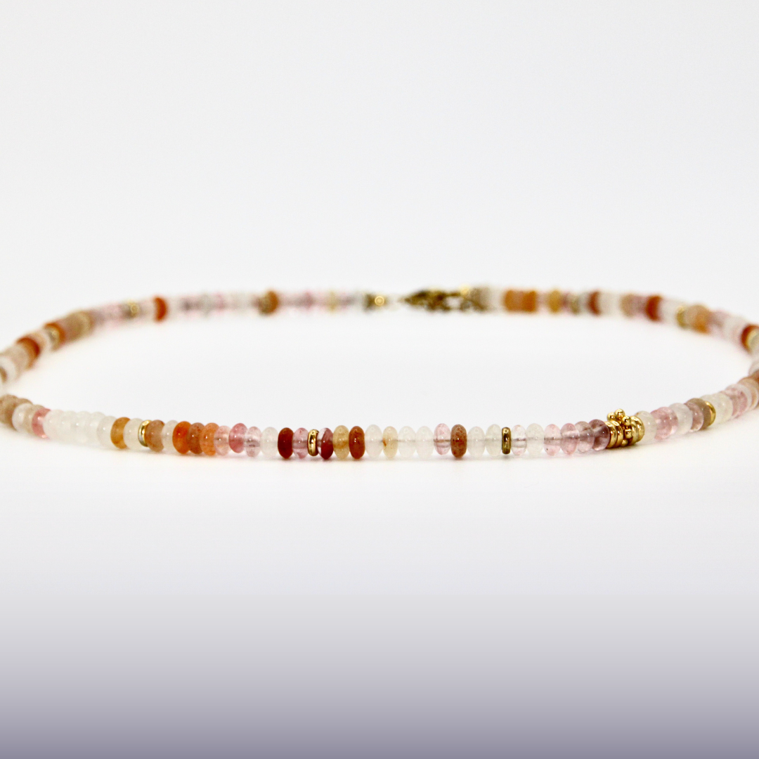 Beige-roséfarbener Perlen-Choker mit goldenen Details auf weißem Hintergrund