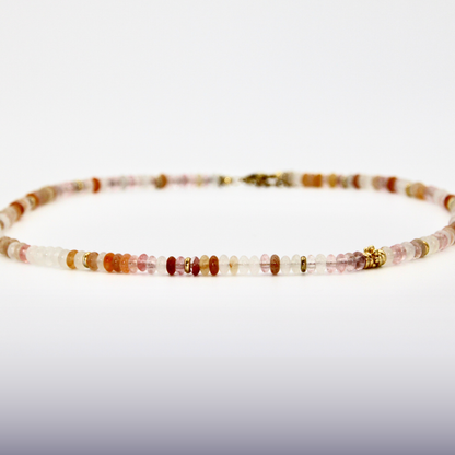 Beige-roséfarbener Perlen-Choker mit goldenen Details auf weißem Hintergrund