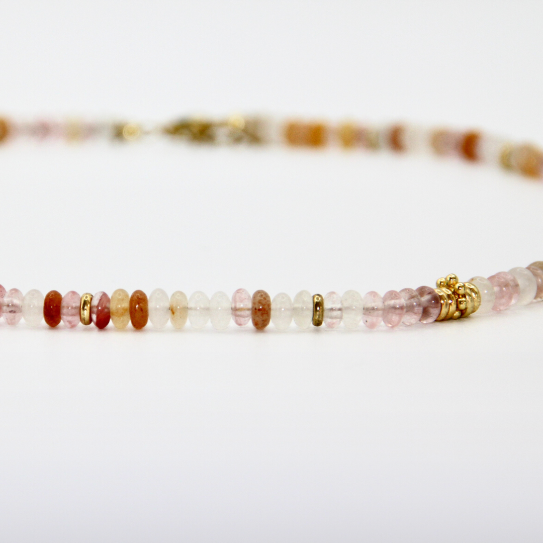 Detailaufnahme eines beige-roséfarbenen Perlen-Chokers mit goldenen Zwischenelementen