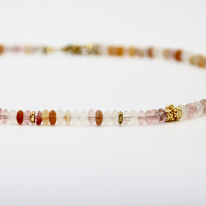 Detailaufnahme eines beige-roséfarbenen Perlen-Chokers mit goldenen Zwischenelementen