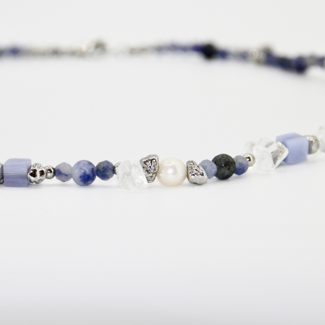 Detailaufnahme eines blau-weißen Perlen-Chokers mit silbernen Zwischenelementen