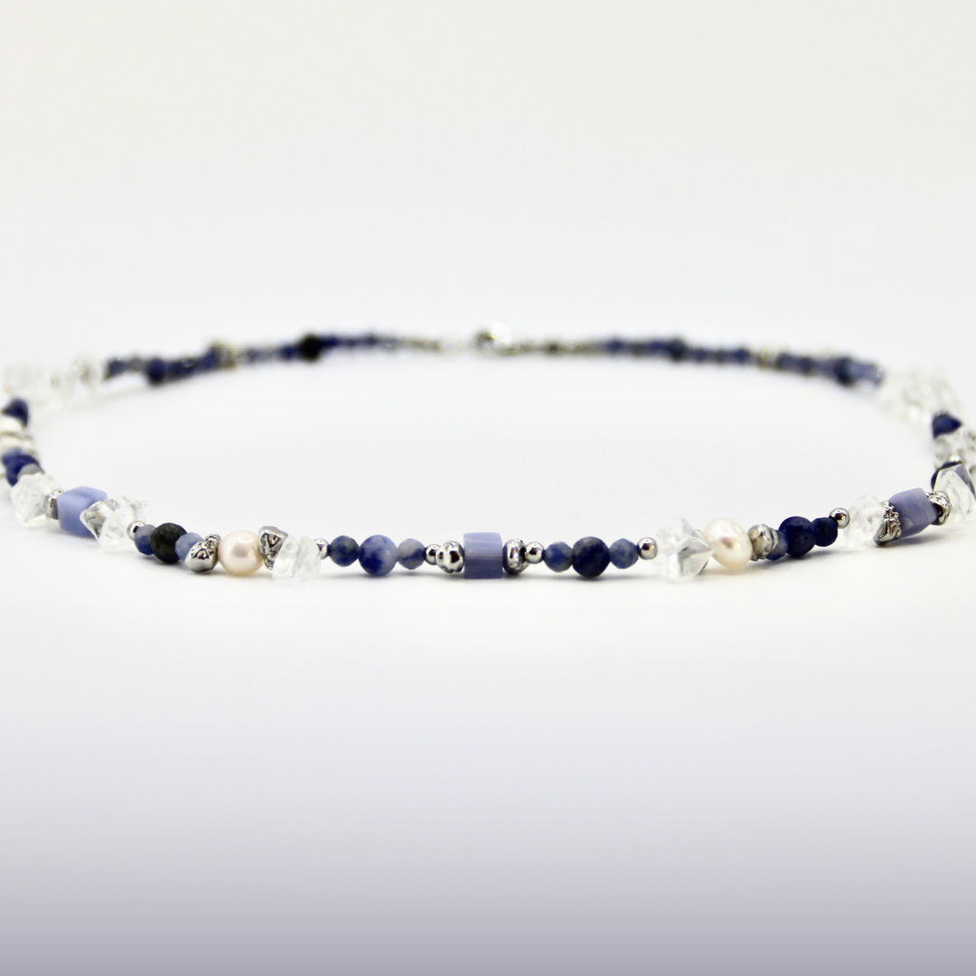 Blau-weißer Perlen-Choker mit silbernen Details auf weißem Hintergrund