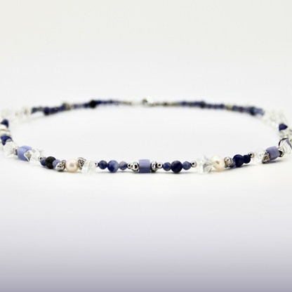 Blau-weißer Perlen-Choker mit silbernen Details auf weißem Hintergrund