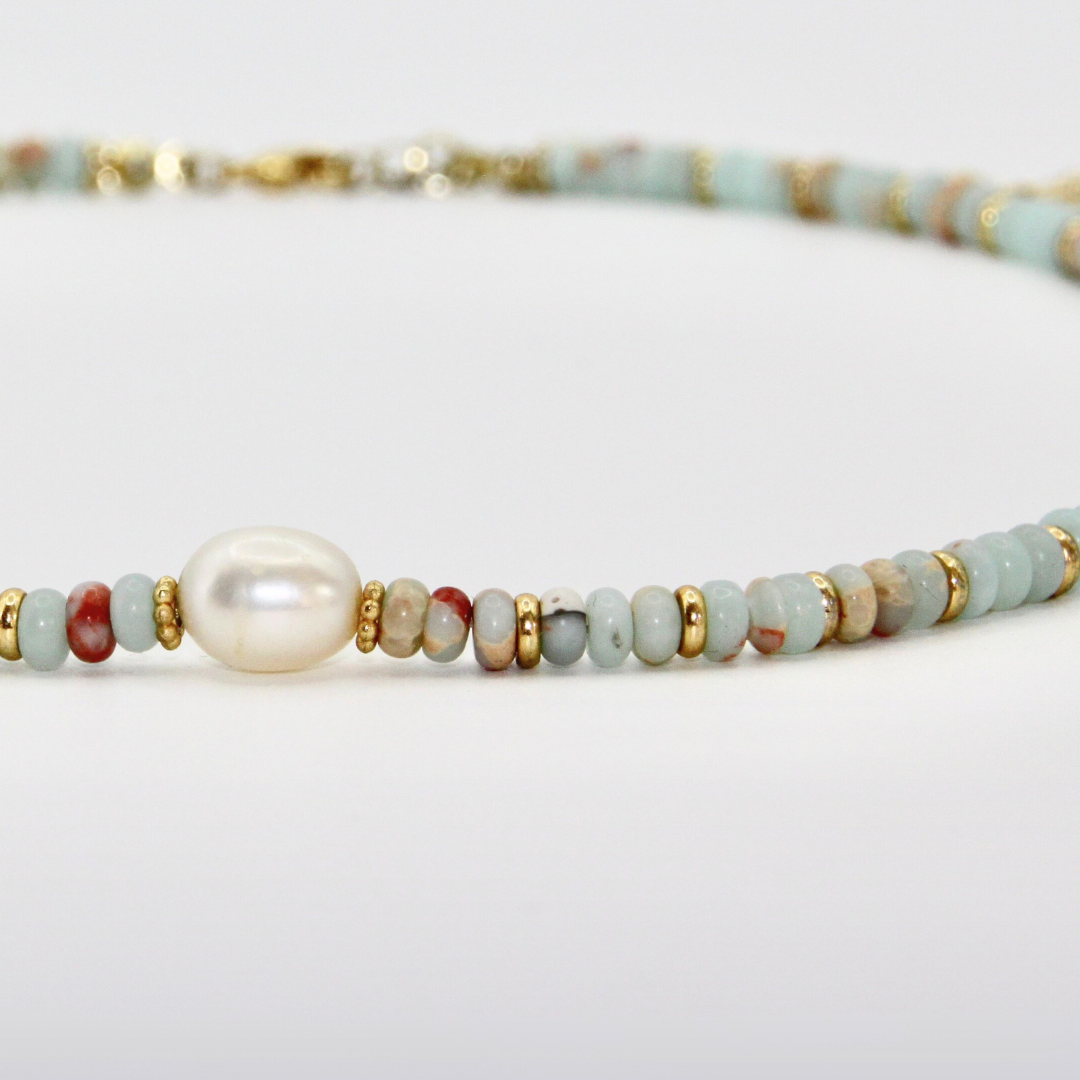 Detailaufnahme eines hellblau-rostfarbenen Perlen-Chokers mit goldenen Zwischenelementen und zentraler Perle