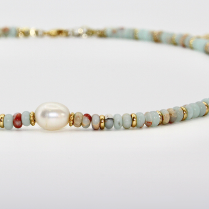 Detailaufnahme eines hellblau-rostfarbenen Perlen-Chokers mit goldenen Zwischenelementen und zentraler Perle