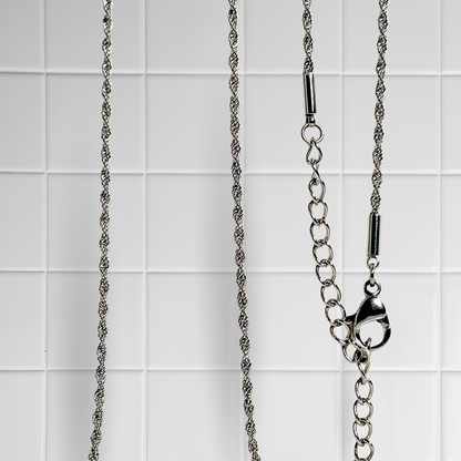 Gedrehte Rope-Kette in Silber vor weißem Kachel-Hintergrund