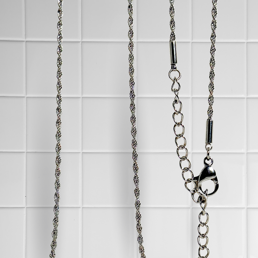 Gedrehte Rope-Kette in Silber vor weißem Kachel-Hintergrund