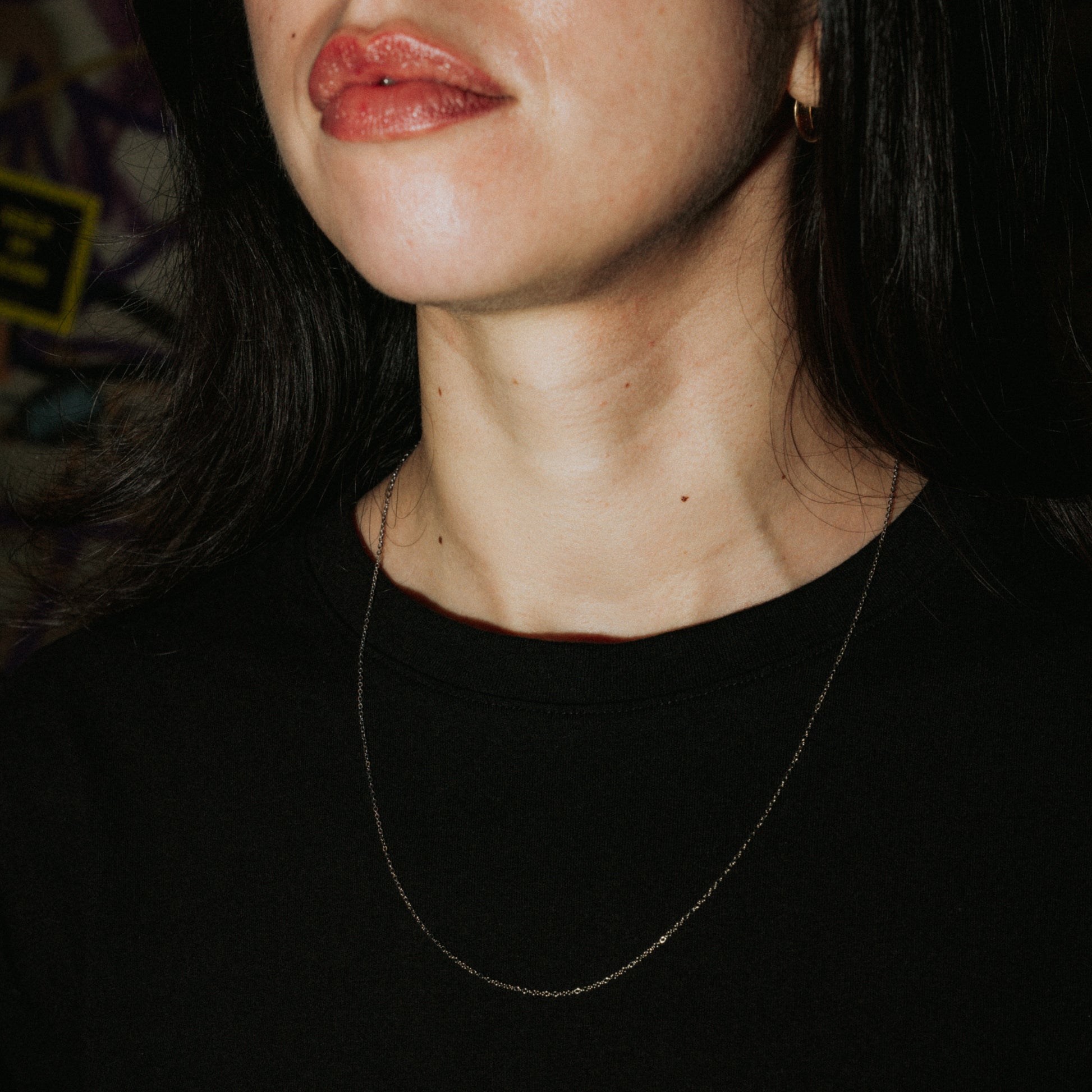 Unisex Silberkette „Lowkey Shy“ lang aus Edelstahl, feine minimalistische Halskette getragen im Close-up.